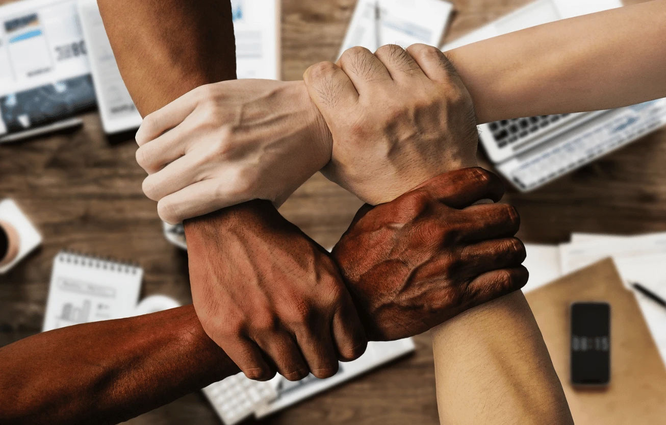 Hands joined together around a table.
