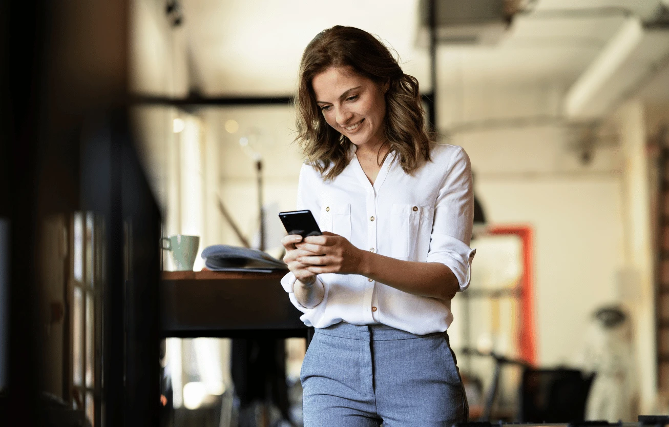 A person smiling while looking at their phone.